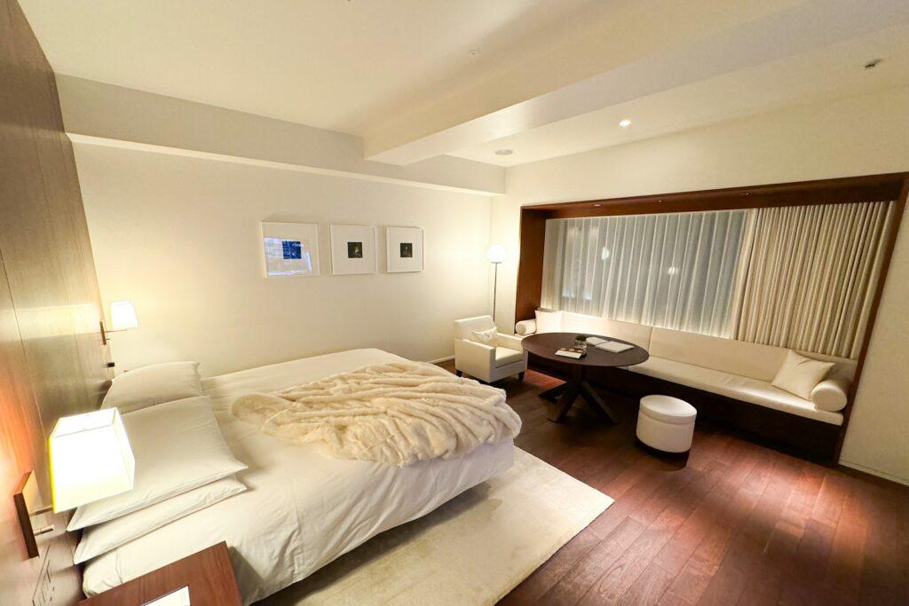 A bedroom with a large bed and wooden floors