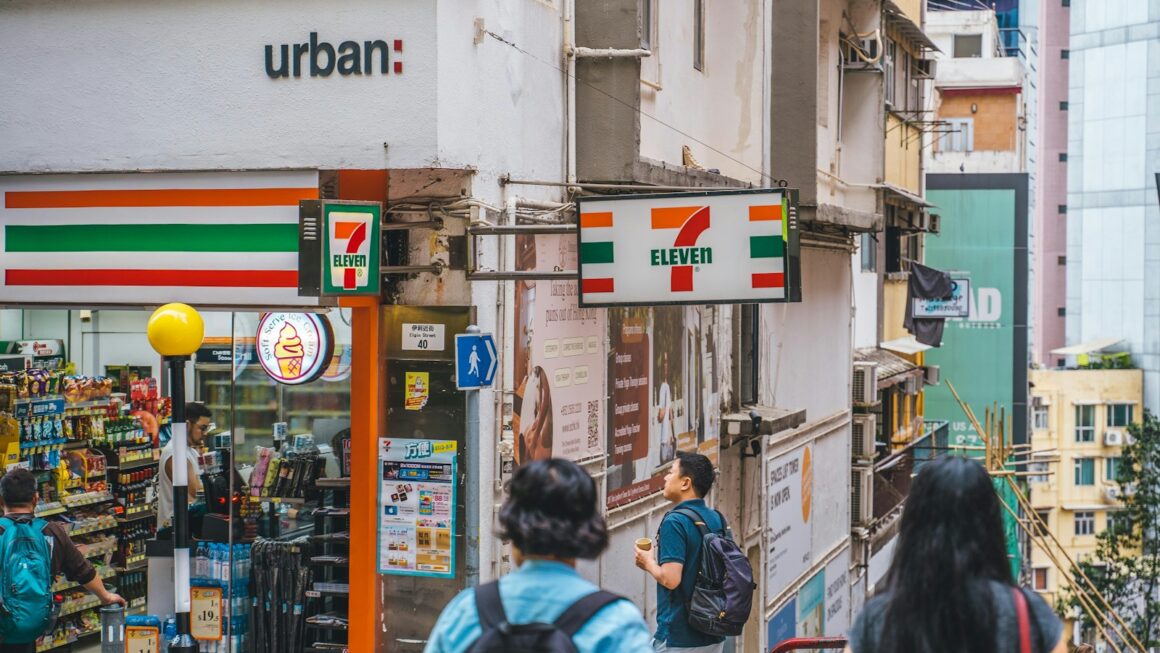 a group of people walking down a street next to a store