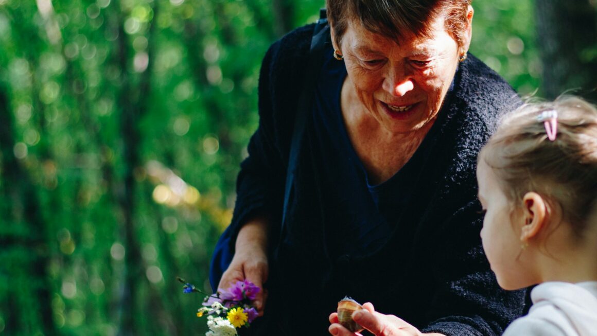 woman in black long sleeve shirt holding purple flower