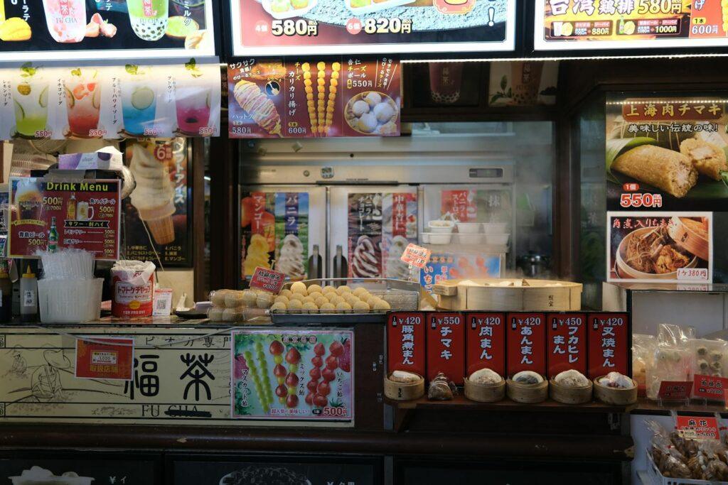 Colorful Yokohama china town street food stall showcasing traditional snacks and drinks menus.